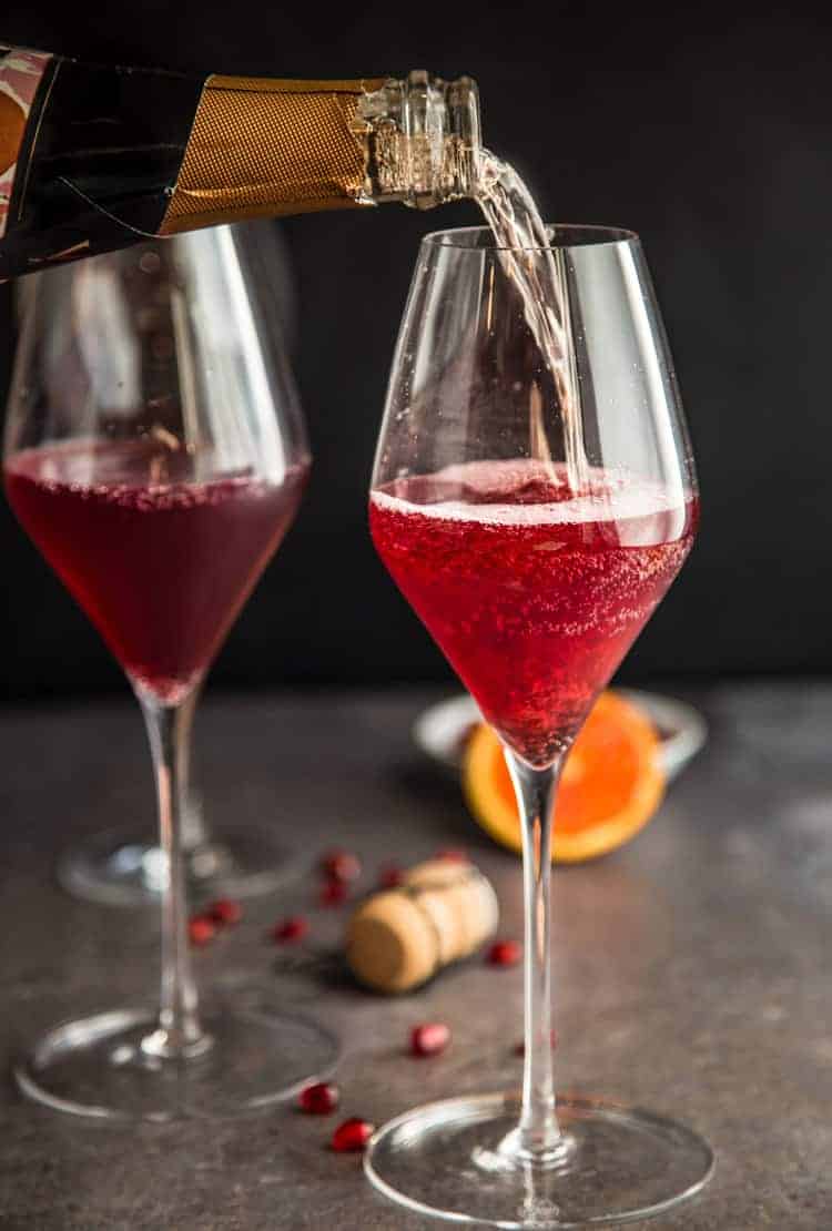 Pomegranate Mimosas being made with Cava sparkling wine. 