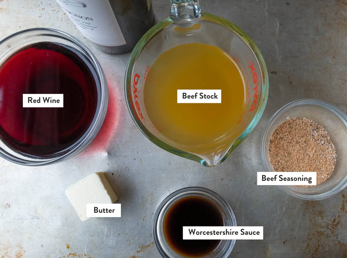 Ingredient photo for a smoked short rib braise including red wine, beef stock, butter, Worcestershire sauce, and beef seasoning.