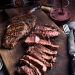 Ribeye steak sliced with a glass of red wine.