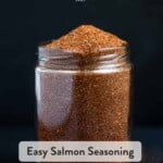 A pinterest pin showing a mason jar piled with salmon seasoning spilling onto the cutting board.