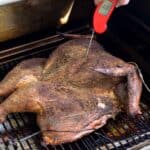 Taking the temperautre of a spatchcocked turkey with the Thermapen One on a pellet grill.