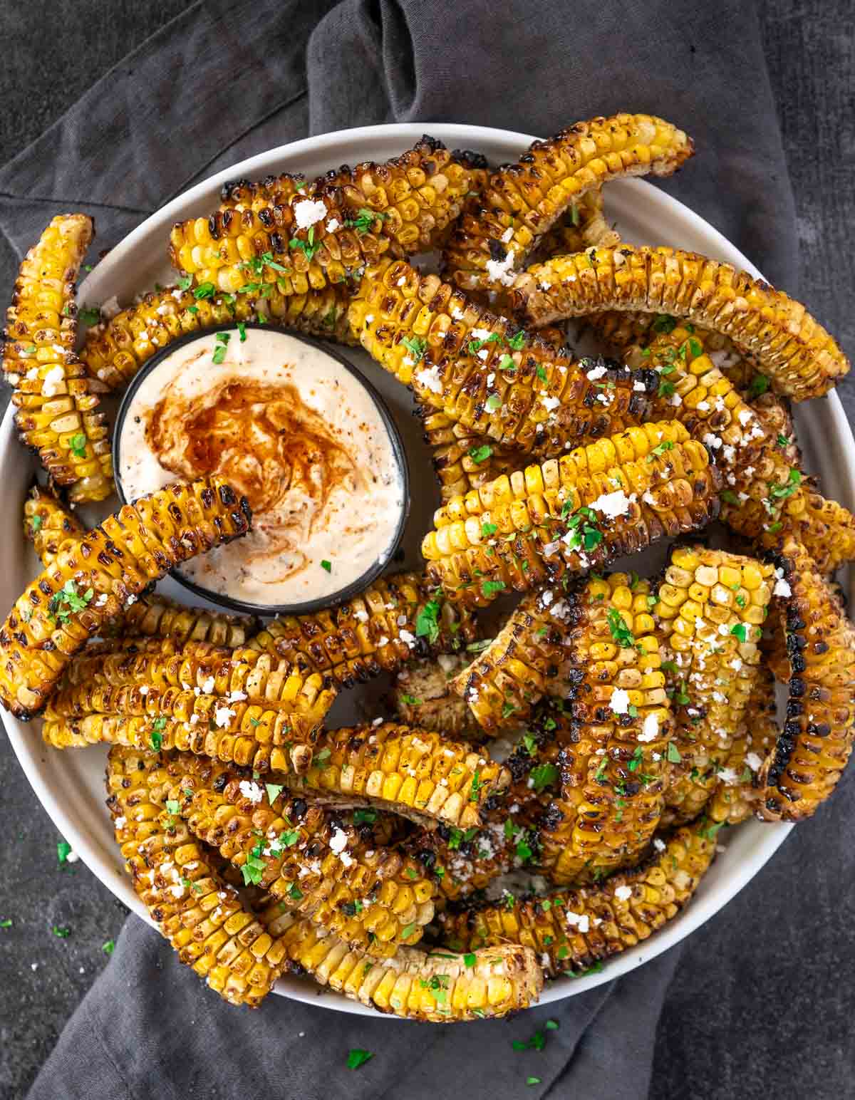 Grilled Corn Ribs on a serving platter with a bowl of corn rib dipping sauce