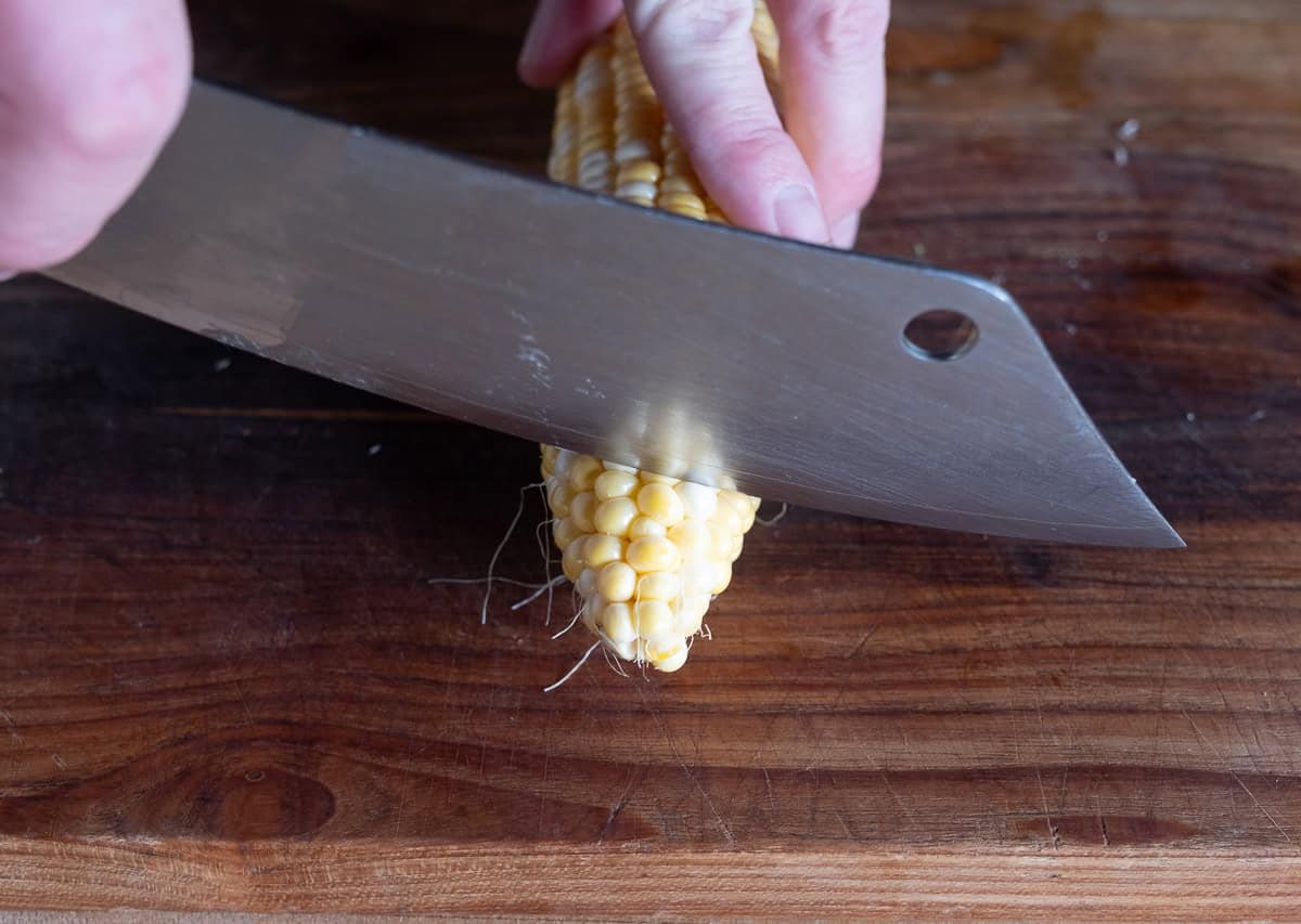 Slicing the tip off of a corn cob.