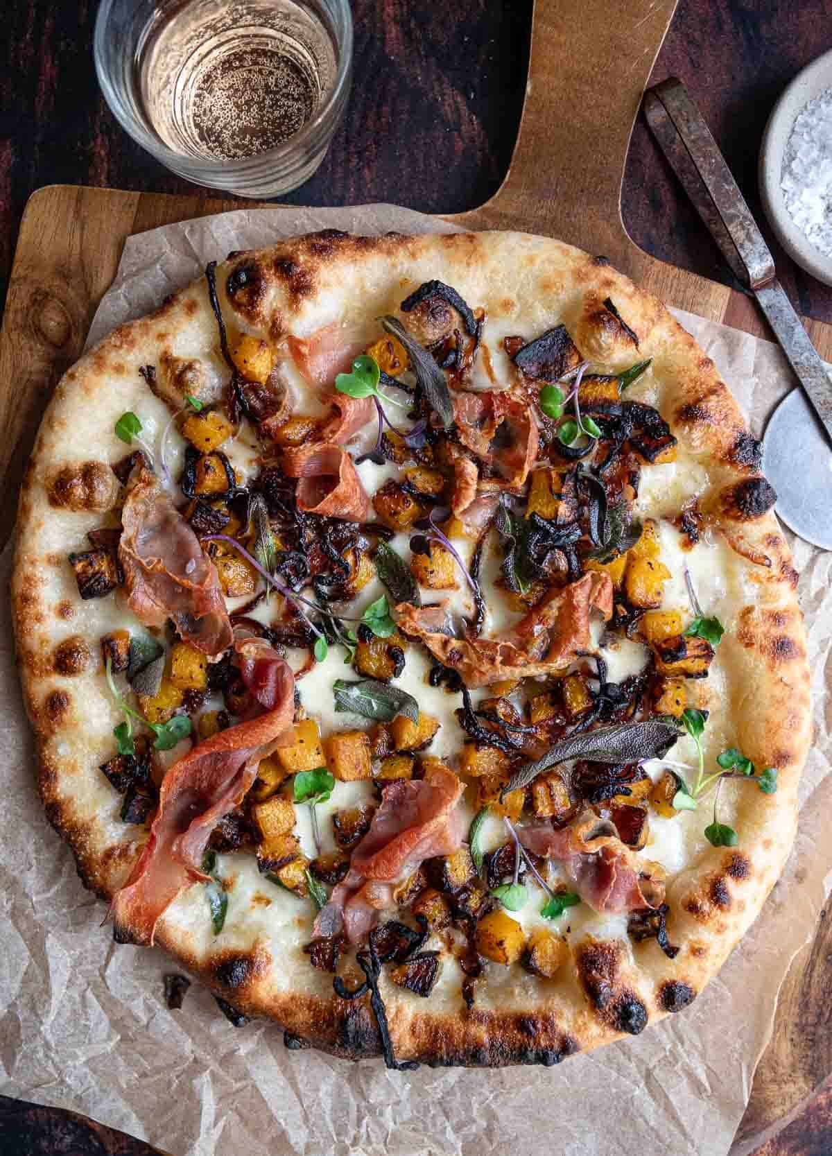 Butternut Squash, Caramelized Onion, and Prosciutto Pizza topped with sage, after being cooked in a pizza oven