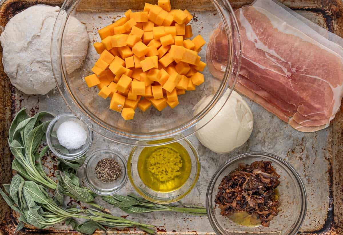 Ingredients for a butternut squash, caramelized onion pizza on a sheet pan 