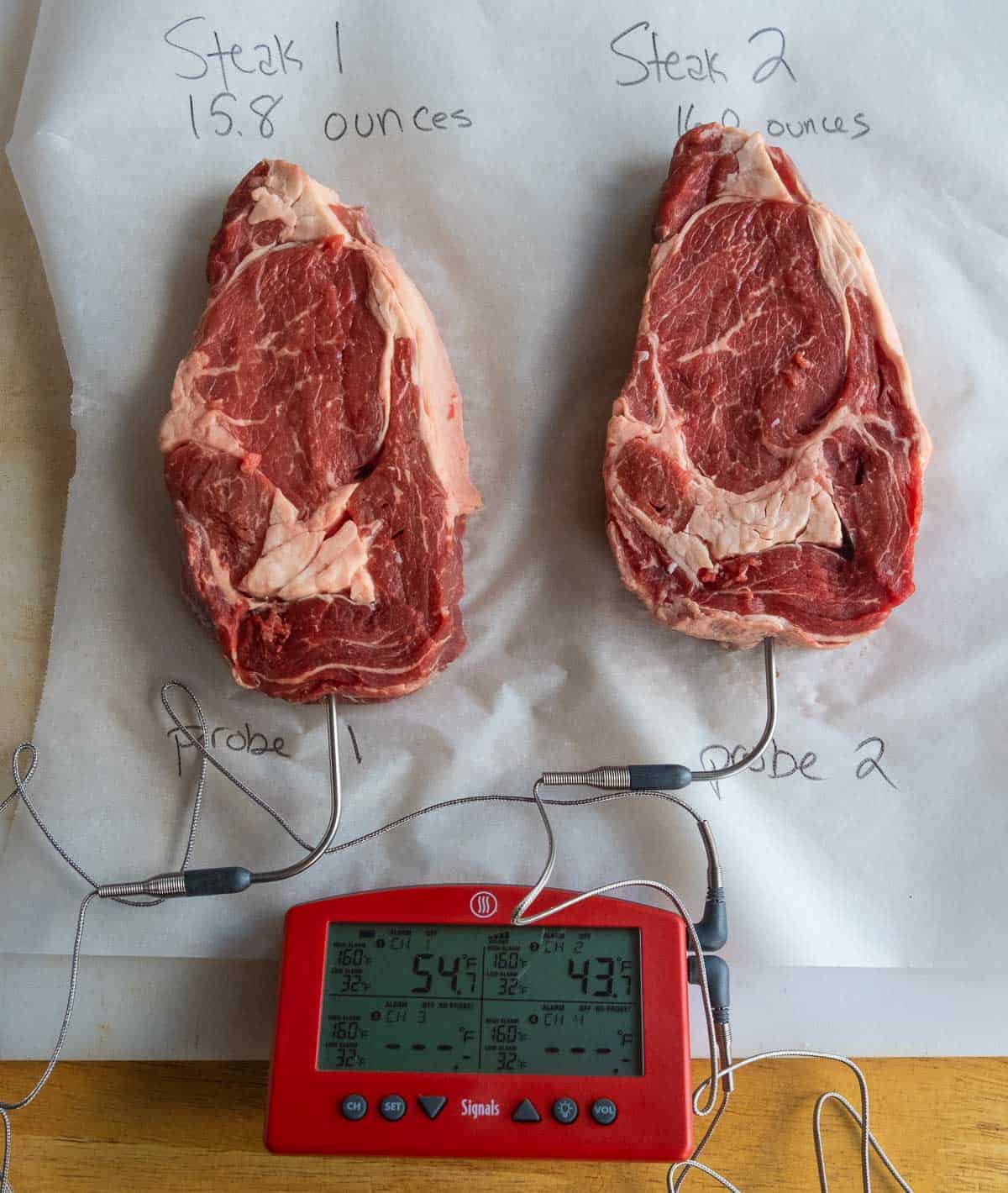 Two steaks coming to room temperature on butcher paper.