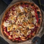 A Thanksgiving leftover turkey pizza on a pizza peel.