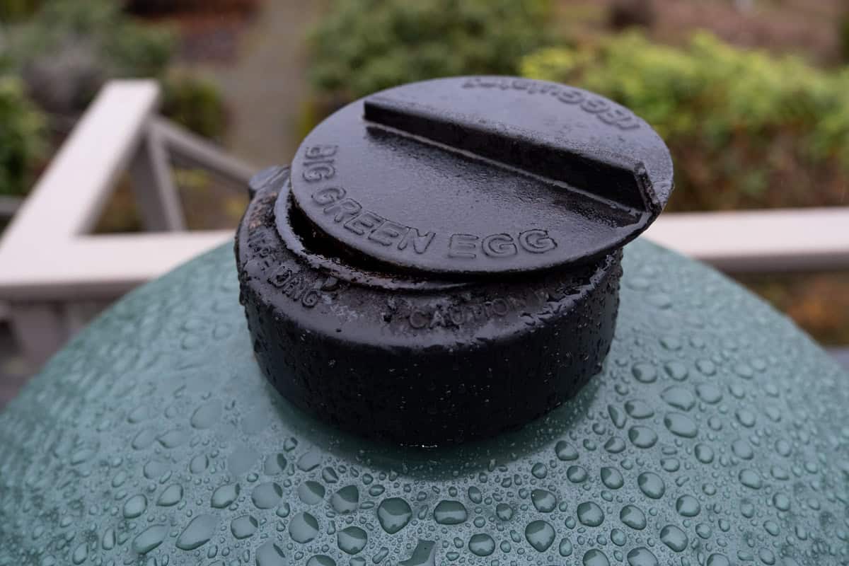 A image of a Big Green Egg regulator cap slightly open about one quarter of an inch.