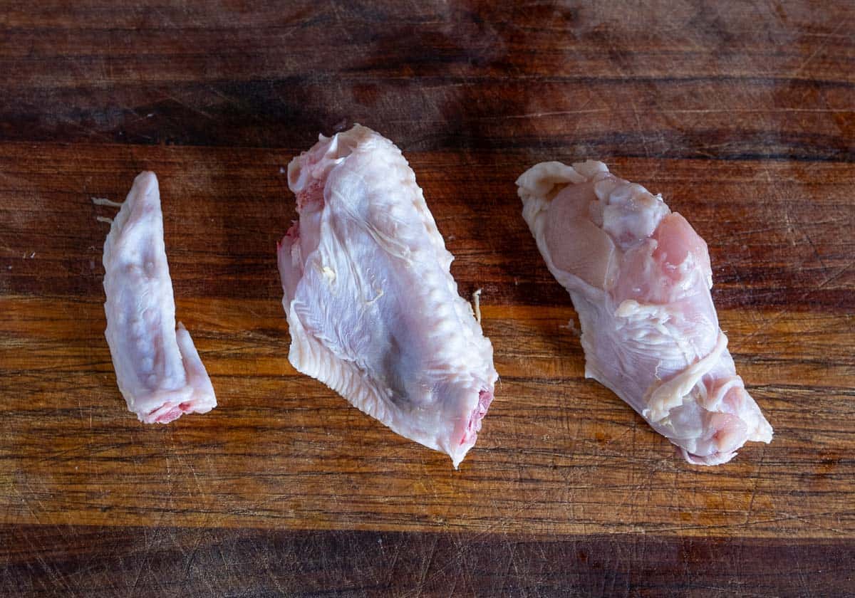 A whole chicken wing, separated into three parts - the drum, the flat, and the winglet.