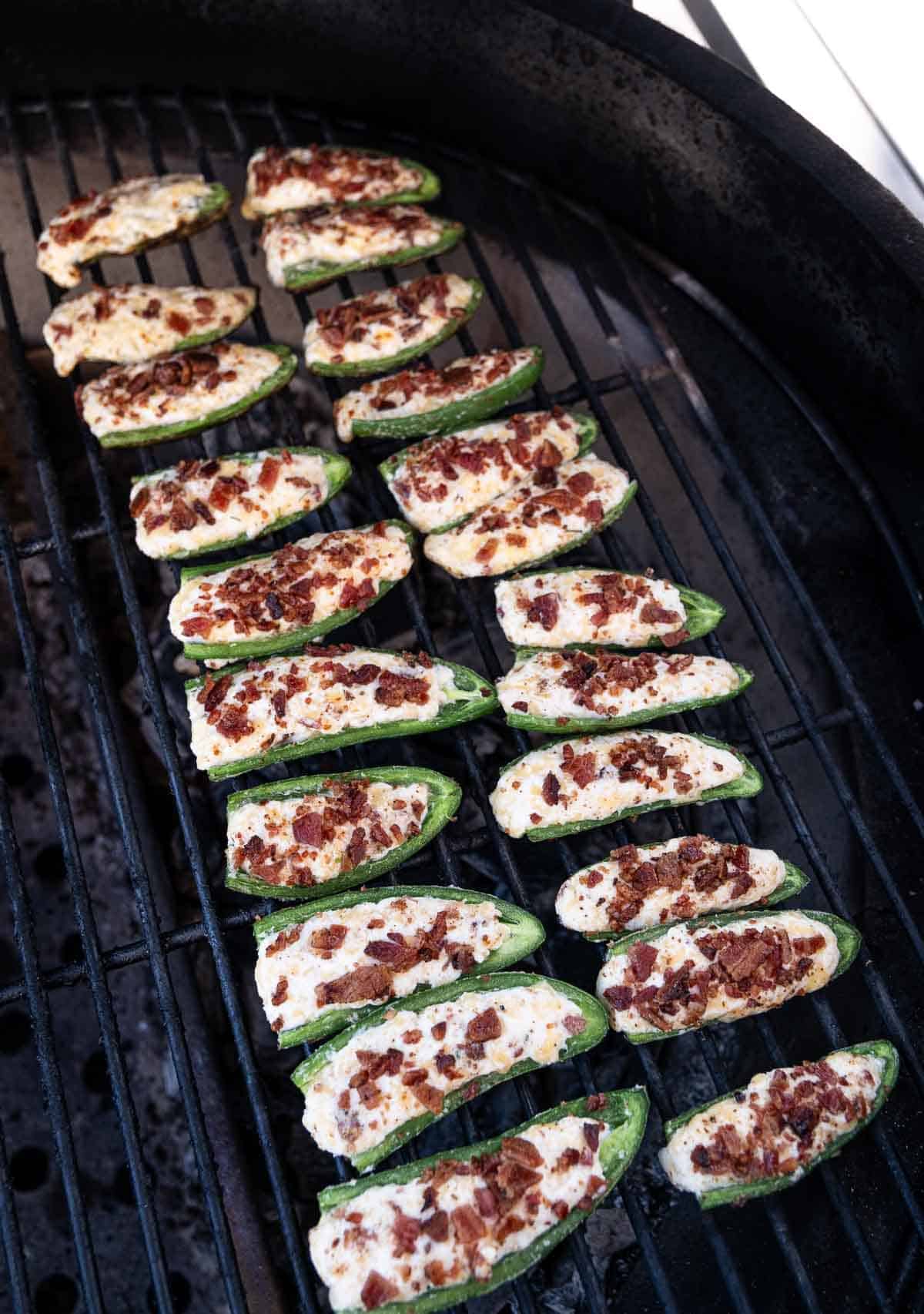 Jalapeño poppers cooking on the grill over direct heat. 