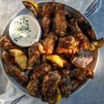 Grilled Lemon Pepper Wings on a platter with a bowl of homemade ranch dressing.