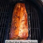 Pinterest pin showing a salmon on a cedar plank over direct heat glazed with hot honey.