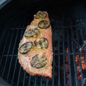 Lemon Garlic Salmon cooking on a charcoal grill.