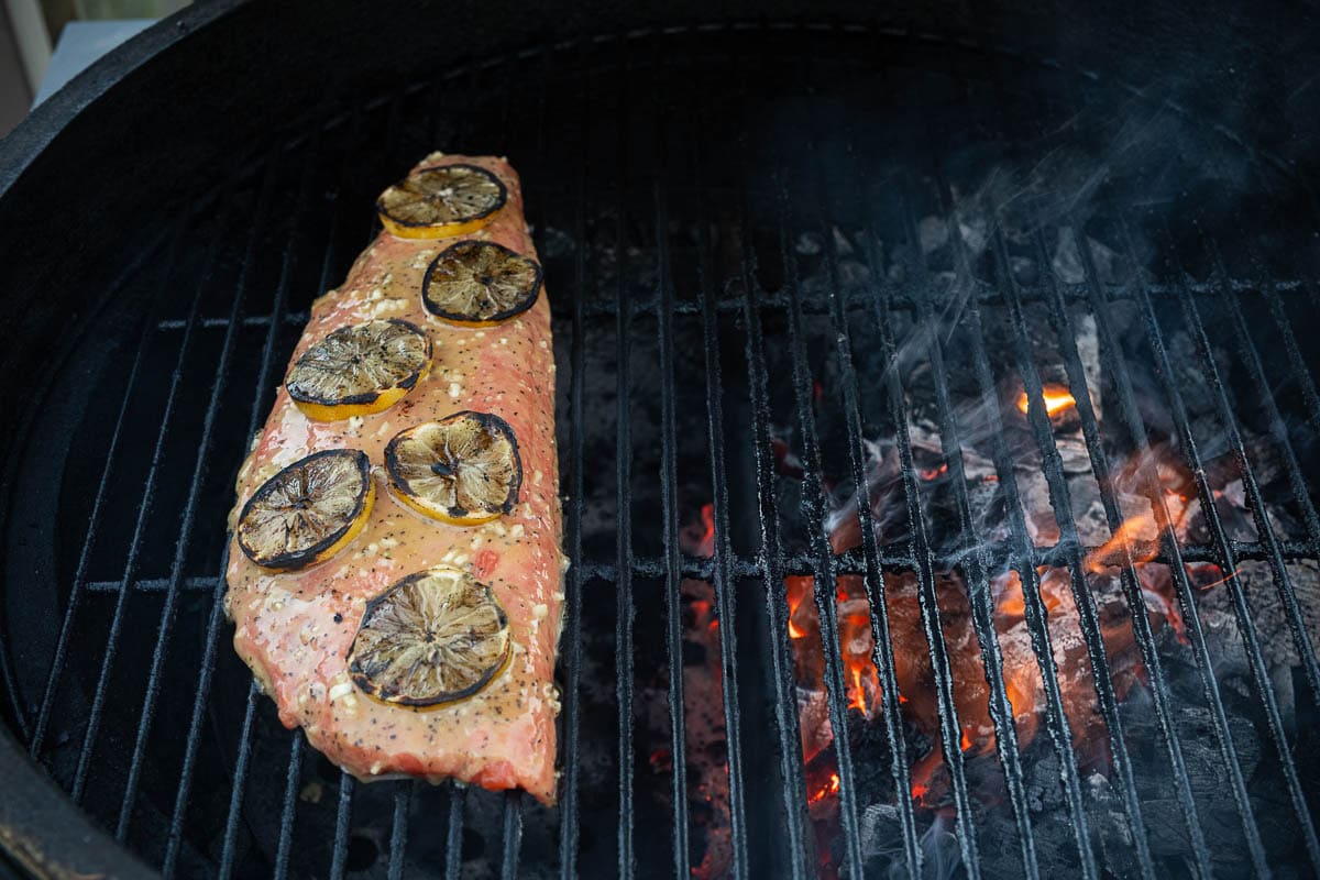 Grilled Lemon Garlic Salmon cooking on a charcoal grill over indirect heat.